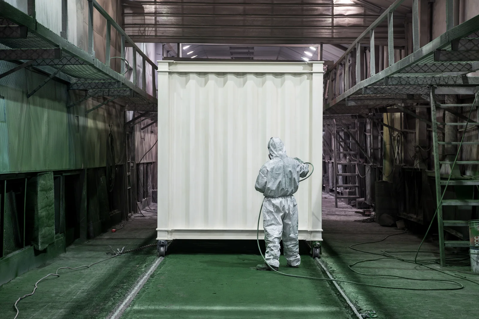 温湿度を管理した塗装ブースで、建築用コンテナモジュールに上塗りを吹き付ける塗装工程