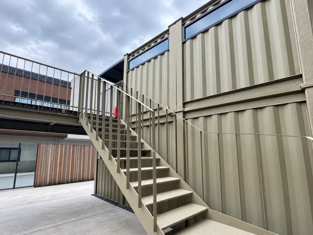 コンテナ建築の外部鉄骨階段。躯体と同色で仕上げた一体感のある設計、モジュール建築工場 Yustellar Cubox。